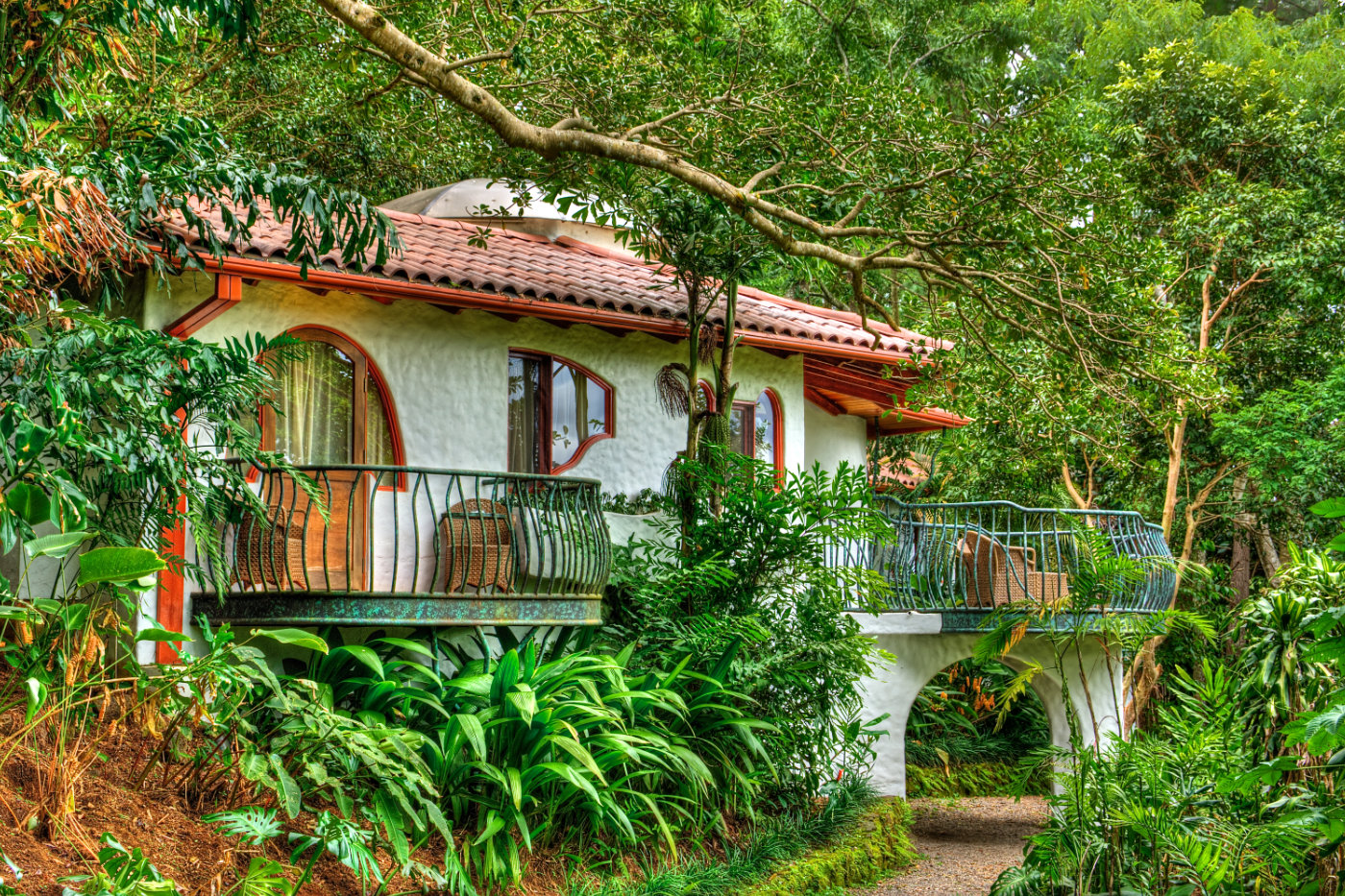 The charming whitewashed main building of Finca Rosa Blanca surrounded by tropical gardens